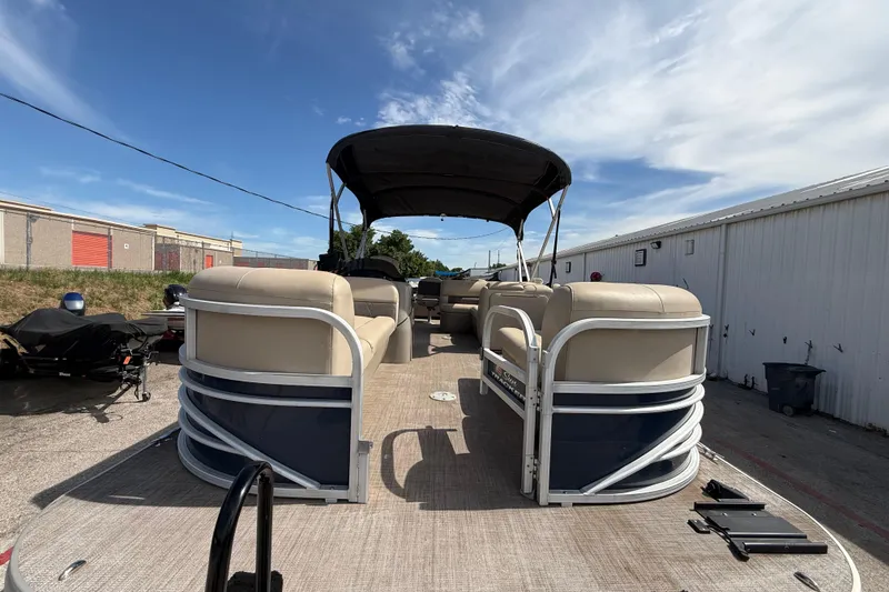 Slide: The Image of 2021 Sun Tracker SportFish 22 DLX pontoon boat with canopy, parked outdoors. - 24
