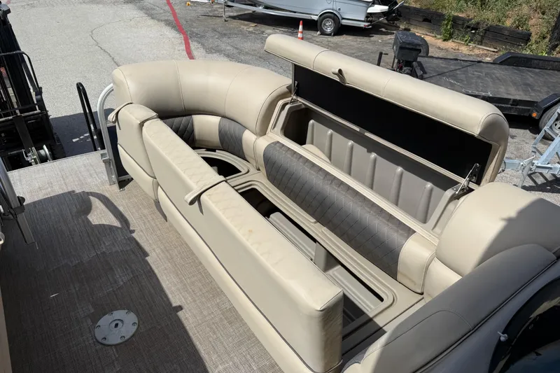 Slide: The Image of 2021 Sun Tracker SportFish 22 DLX pontoon boat with beige seating and storage compartment. - 26