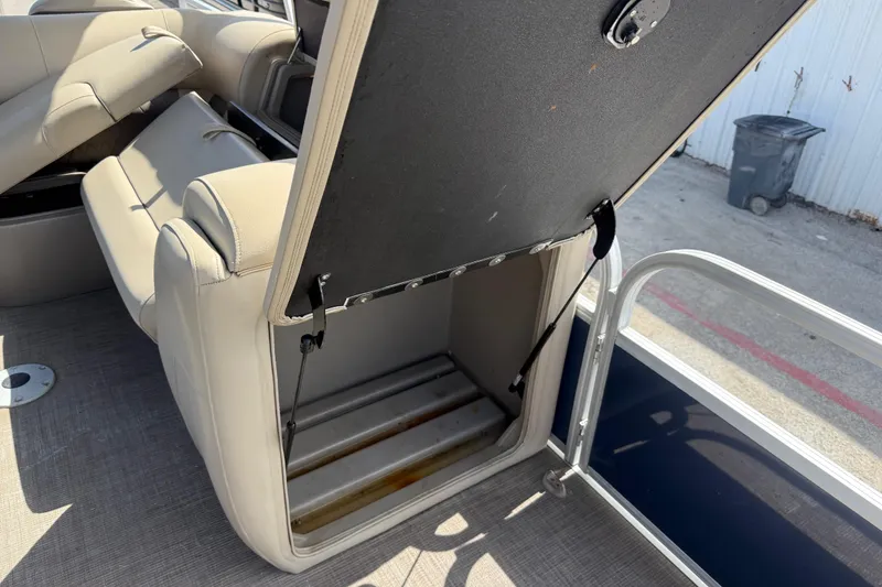 Slide: The Image of Open storage compartment on 2021 Sun Tracker SportFish 22 DLX boat with beige seating. - 30