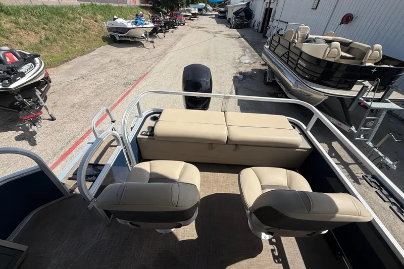 Slide: The Image of 2021 Sun Tracker SportFish 22 DLX pontoon boat with beige seating, parked outdoors. - 43
