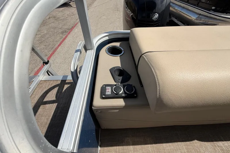 Slide: The Image of 2021 Sun Tracker SportFish 22 DLX boat interior with beige seating and control panel. - 44