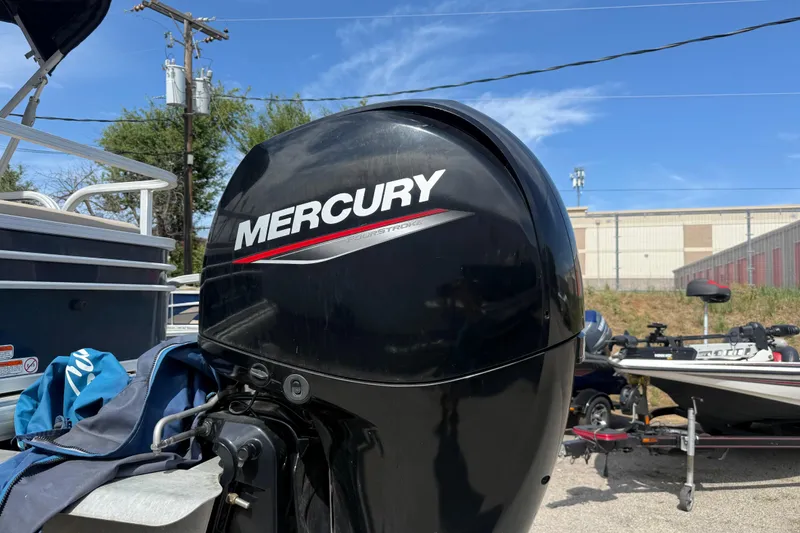 Slide: The Image of Mercury outboard motor on a 2021 Sun Tracker SportFish 22 DLX boat, parked outdoors. - 7