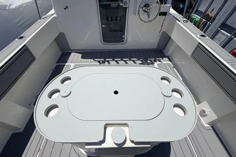 Slide: The Image of 2026 Defiance Admiral 270 EX boat deck with table and steering wheel. - 21
