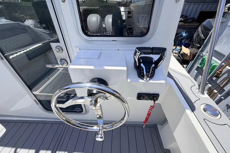 Slide: The Image of Helm of 2026 Defiance Admiral 270 EX boat with steering wheel and controls. - 26