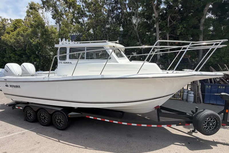 Slide: The Image of 2026 Defiance Admiral 270 EX boat on trailer, parked outdoors. - 3