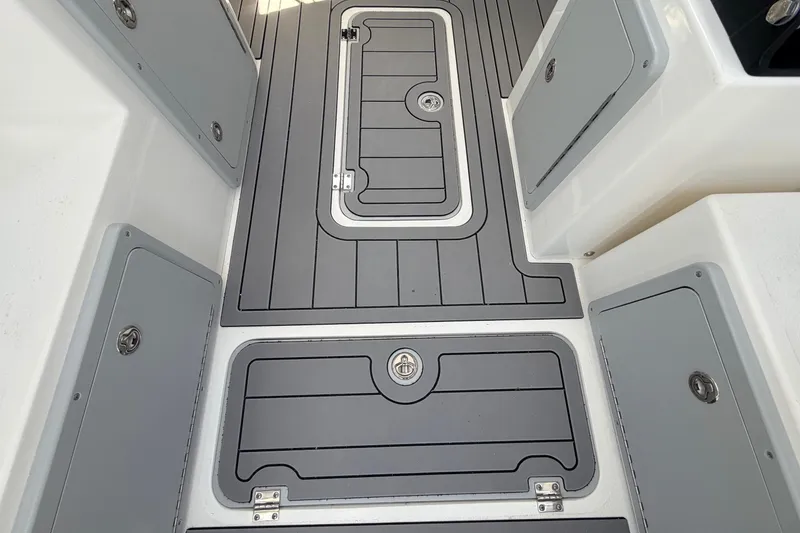 Slide: The Image of 2026 Defiance Admiral 270 EX boat deck with storage compartments and sleek design. - 32