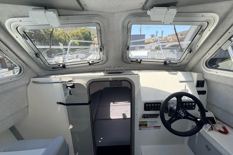 Slide: The Image of Interior view of 2026 Defiance Admiral 270 EX boat cockpit with steering wheel and windows. - 43