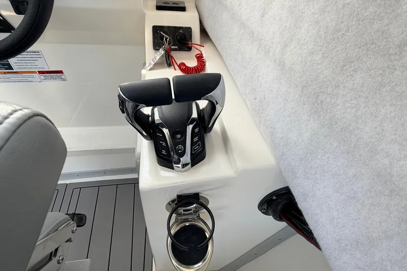 Slide: The Image of Control panel of 2026 Defiance Admiral 270 EX boat with throttle and cup holder. - 47