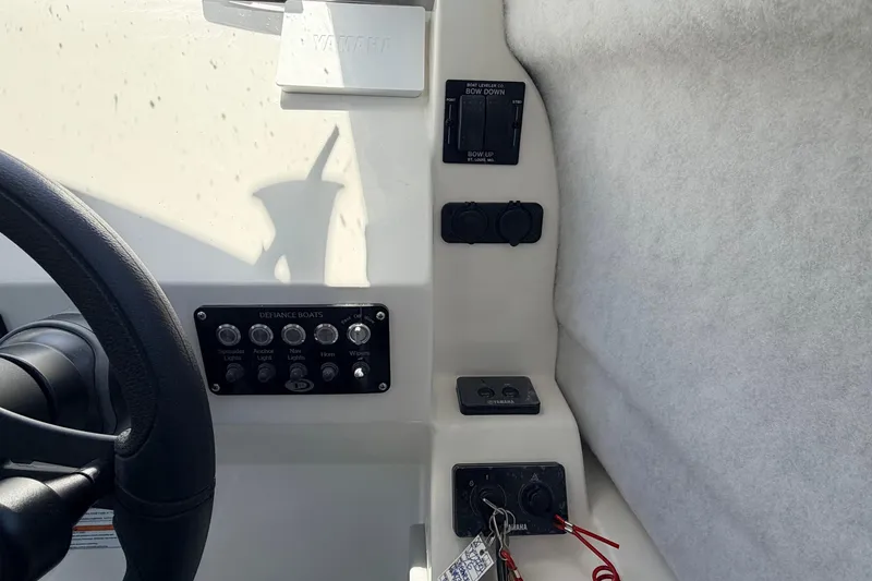 Slide: The Image of Interior controls of 2026 Defiance Admiral 270 EX boat, featuring steering wheel and switch panel. - 48