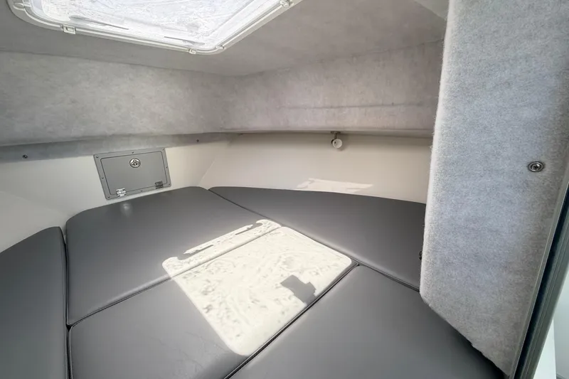 Slide: The Image of Interior cabin of 2026 Defiance Admiral 270 EX boat, featuring cushioned seating and overhead hatch. - 54