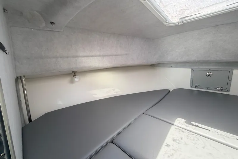 Slide: The Image of Interior cabin of 2026 Defiance Admiral 270 EX boat with gray cushions and overhead hatch. - 55
