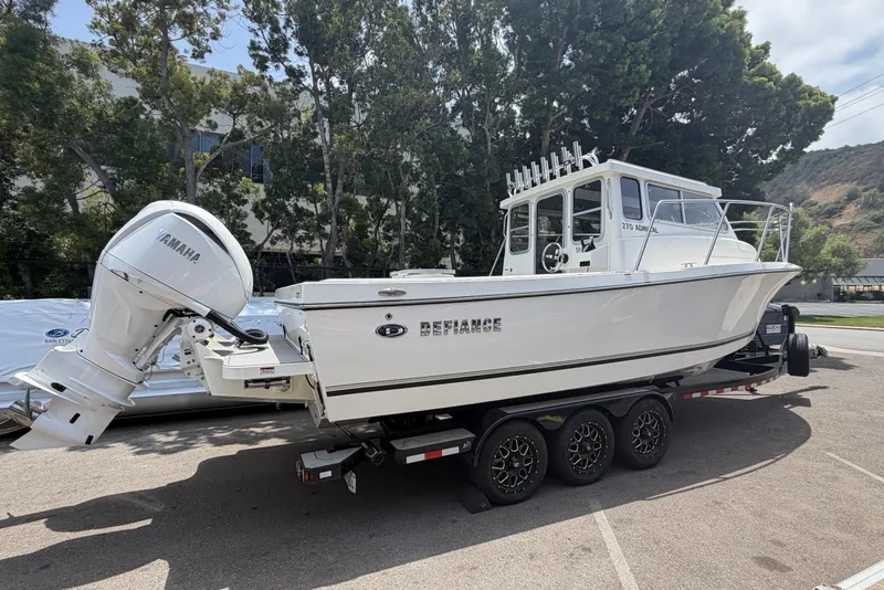 Slide: The Image of 2026 Defiance Admiral 270 EX boat on trailer with Yamaha outboard motor, parked outdoors. - 6