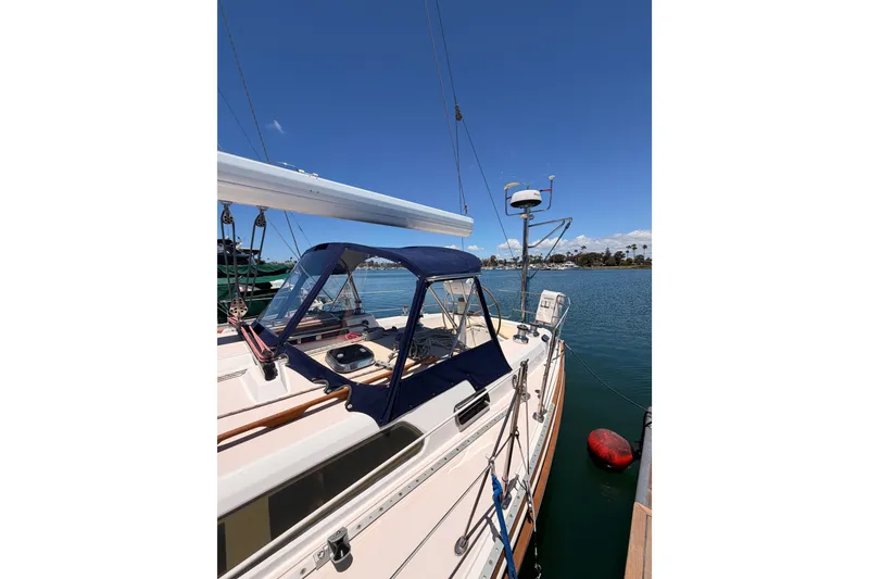 Slide: The Image of 2002 Sabre 362 sailboat docked, featuring a blue canopy and clear skies. - 10
