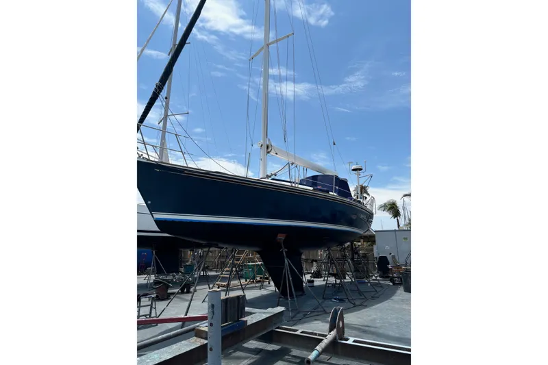 Slide: The Image of 2002 Sabre 362 sailboat on stands in a boatyard under a clear blue sky. - 91