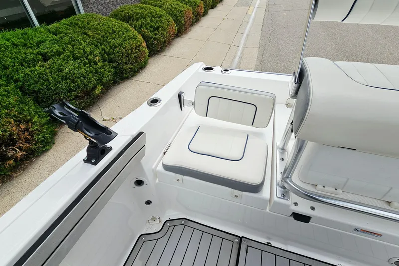 Slide: The Image of 2020 Yamaha Boats 195 FSH Sport interior with seating and rod holder, dockside view. - 13