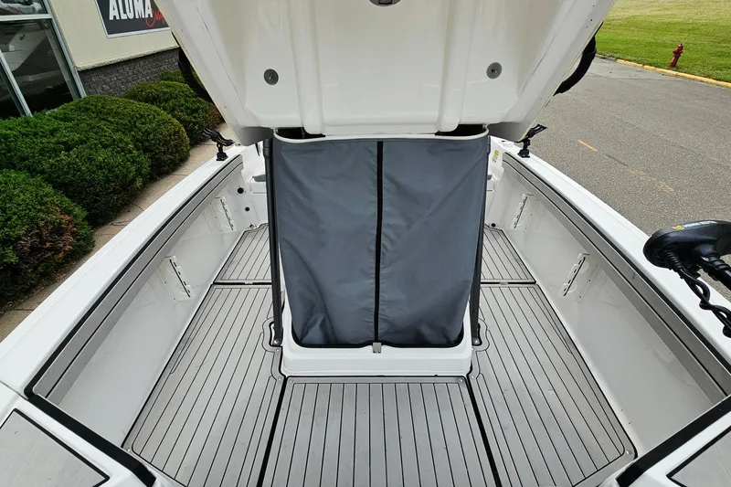Slide: The Image of 2020 Yamaha Boats 195 FSH Sport interior with open storage compartment, gray flooring. - 19