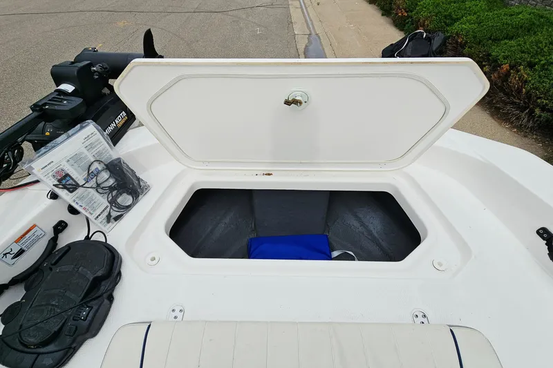 Slide: The Image of 2020 Yamaha Boats 195 FSH Sport storage compartment open, showcasing interior space and accessories. - 20