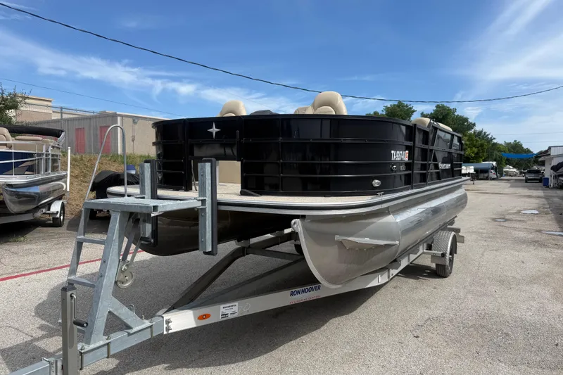 The Image of 2023 Berkshire 20A CTS pontoon boat on trailer, parked outdoors under blue sky. - 1