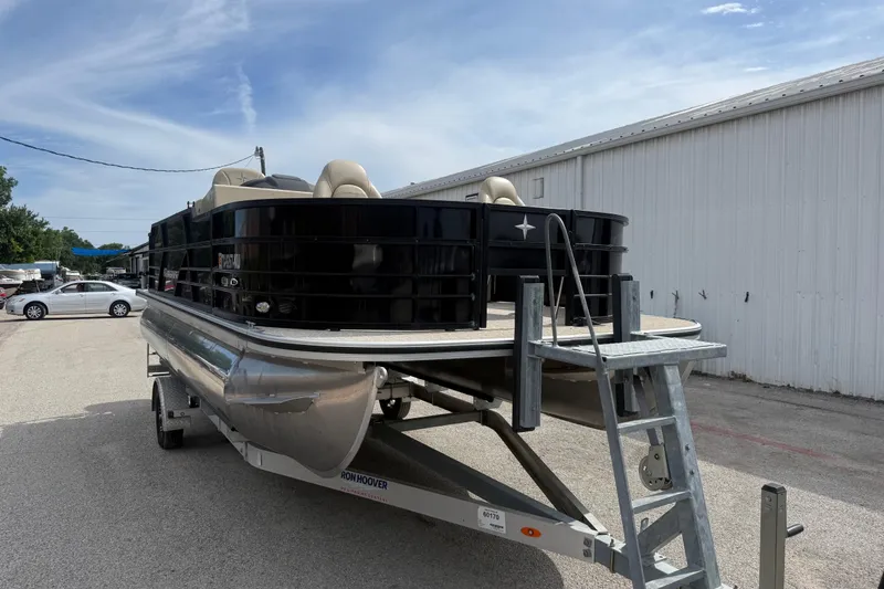 Slide: The Image of 2023 Berkshire 20A CTS pontoon boat on trailer, parked outdoors near a white building. - 18