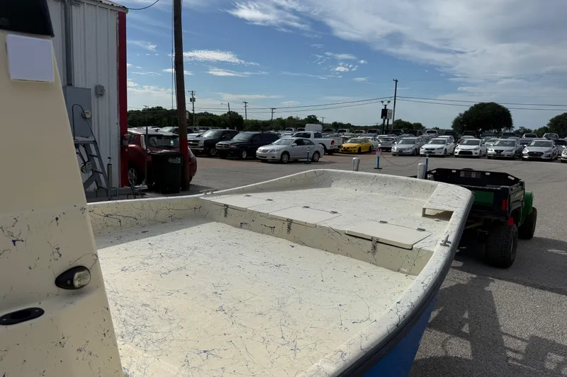 Slide: The Image of 2007 Flats Cat 19 boat on trailer in parking lot with cars and cloudy sky. - 15