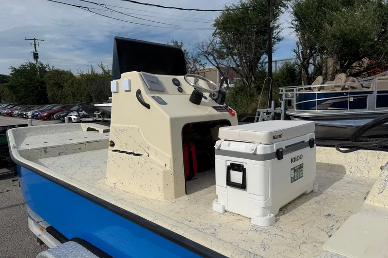 Slide: The Image of 2007 Flats Cat 19 boat with Igloo cooler on deck, parked outdoors. - 23
