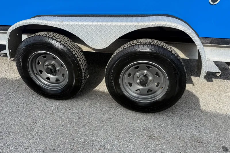 Slide: The Image of Trailer wheels of a 2007 Flats Cat 19 boat on asphalt surface. - 24
