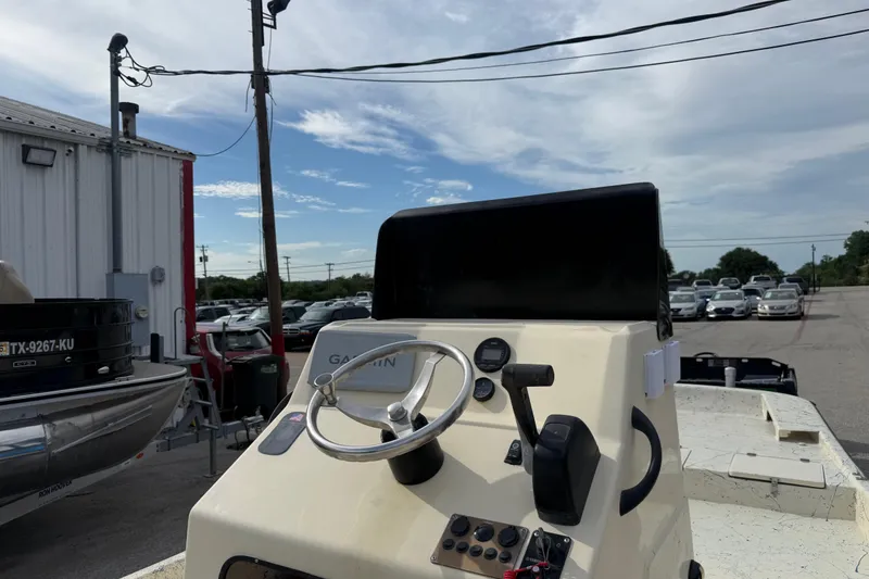 Slide: The Image of 2007 Flats Cat 19 boat dashboard with steering wheel and controls, parked outdoors. - 27