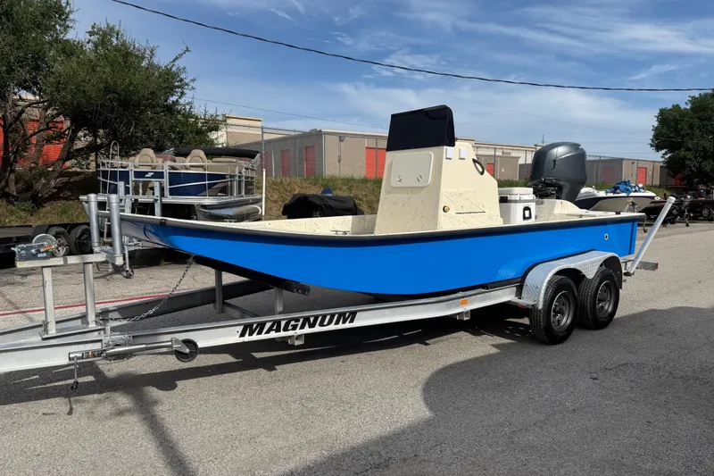 Slide: The Image of 2007 Flats Cat 19 boat on a Magnum trailer, parked outdoors. - 3