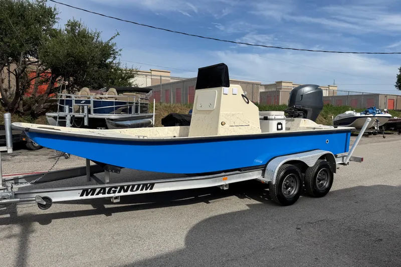 Slide: The Image of 2007 Flats Cat 19 boat on Magnum trailer, blue hull, parked outdoors. - 4