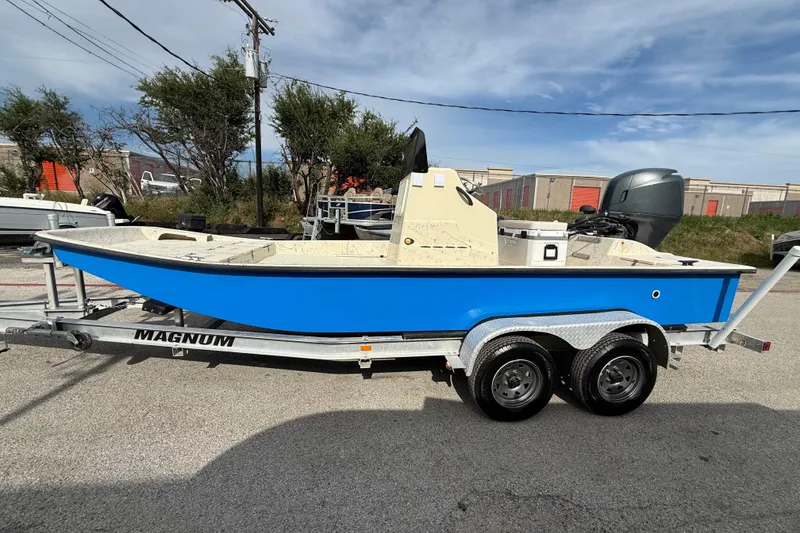 Slide: The Image of Blue 2007 Flats Cat 19 boat on a Magnum trailer, parked outdoors. - 5