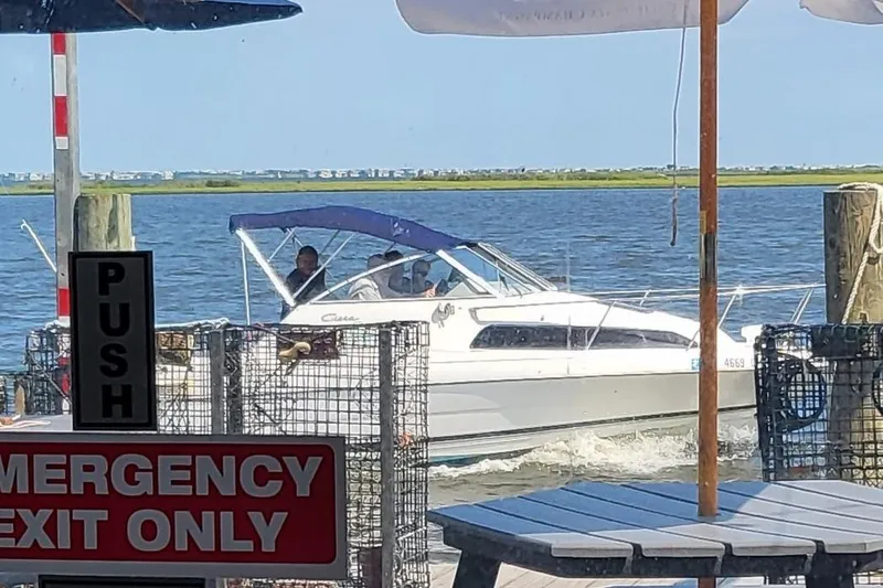 Slide: The Image of 2000 Bayliner 2252 Ciera Express cruising near dock with emergency exit sign. - 27