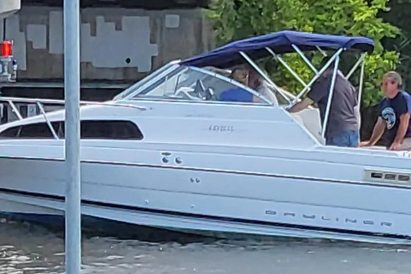 Slide: The Image of 2000 Bayliner 2252 Ciera Express boat with blue canopy on a calm waterway. - 29