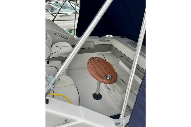 Slide: The Image of Interior of a 2000 Bayliner 2252 Ciera Express boat with seating and a wooden table. - 9