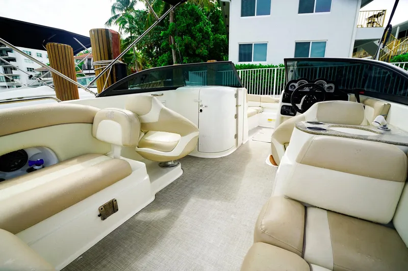 Slide: The Image of 2017 NauticStar 243DC Sport Deck interior with beige seating and modern dashboard. - 10