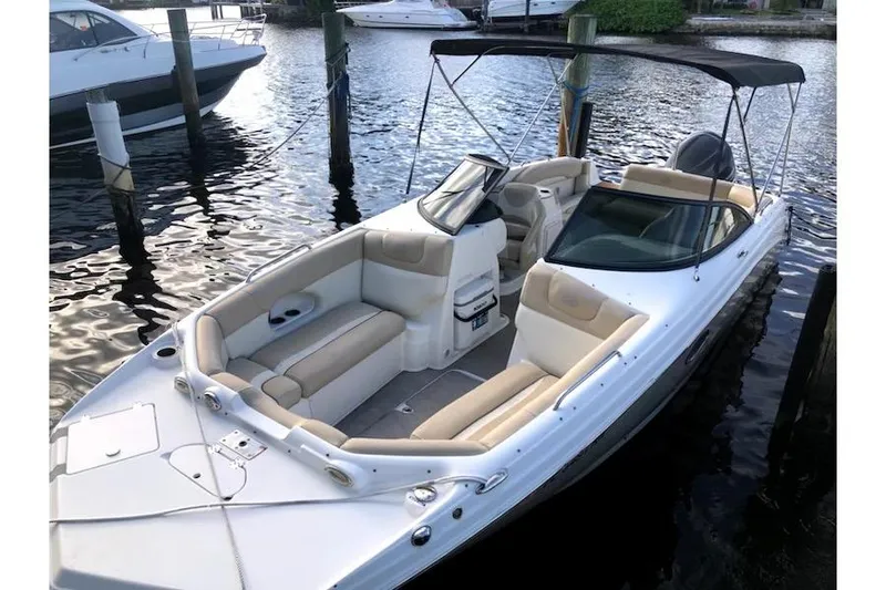 Slide: The Image of 2017 NauticStar 243DC Sport Deck boat docked on calm water. - 2