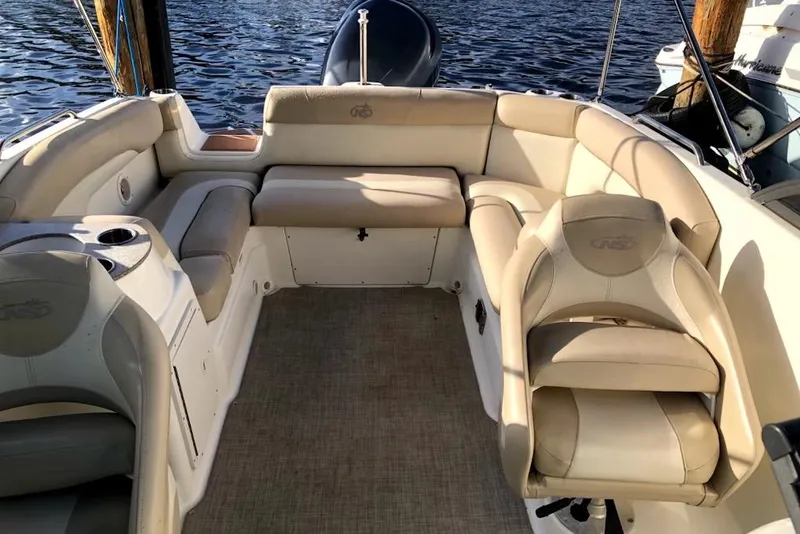 Slide: The Image of 2017 NauticStar 243DC Sport Deck boat interior with beige seating and cup holders. - 4