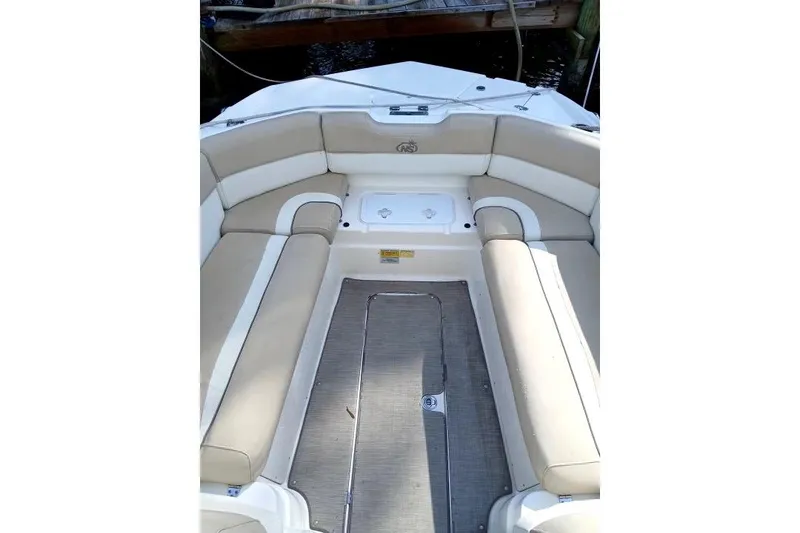 Slide: The Image of 2017 NauticStar 243DC Sport Deck boat interior with beige seating and deck flooring. - 7