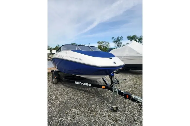 The Image of 2012 Sea-Doo Sport Boats 180 Challenger on trailer, blue and white design, parked outdoors. - 1