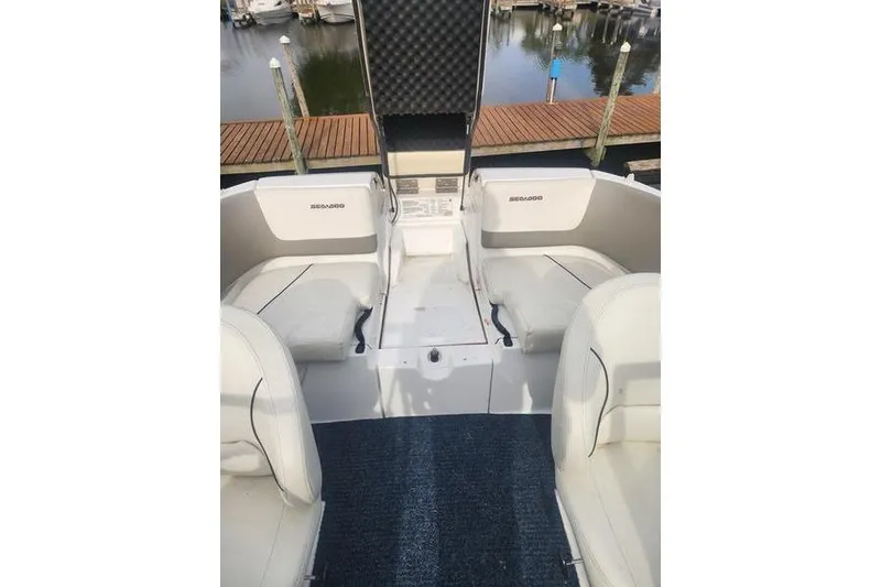 Slide: The Image of 2012 Sea-Doo Sport Boats 180 Challenger interior with seating and storage, dockside view. - 14