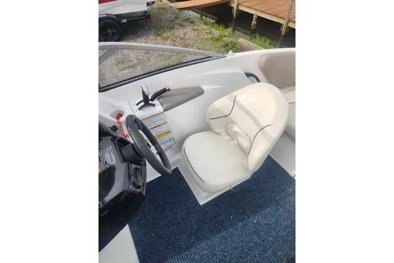 Slide: The Image of 2012 Sea-Doo 180 Challenger boat interior with steering wheel and white seat. - 18