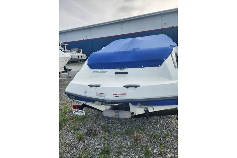 Slide: The Image of 2012 Sea-Doo Sport Boats 180 Challenger with blue cover, parked on gravel. - 3