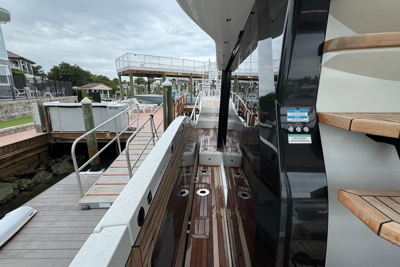 Slide: The Image of 2024 Galeon 560 Fly yacht docked, showcasing sleek design and polished wooden deck. - 59