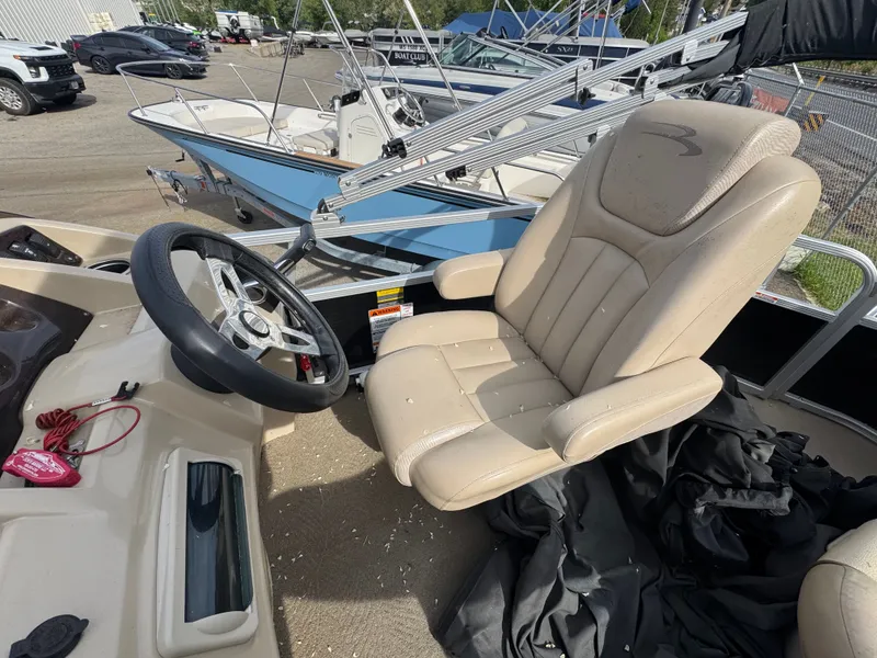 Slide: The Image of Interior of a 2014 Bennington 20SLM pontoon boat with steering wheel and seat. - 14