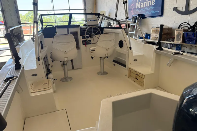 Slide: The Image of 1992 Bayliner 2052 Trophy Walkaround boat interior with white seating and steering console. - 13