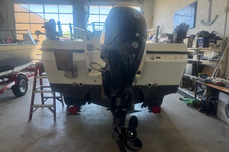 Slide: The Image of 1992 Bayliner 2052 Trophy Walkaround boat in a garage, rear view with outboard motor. - 7