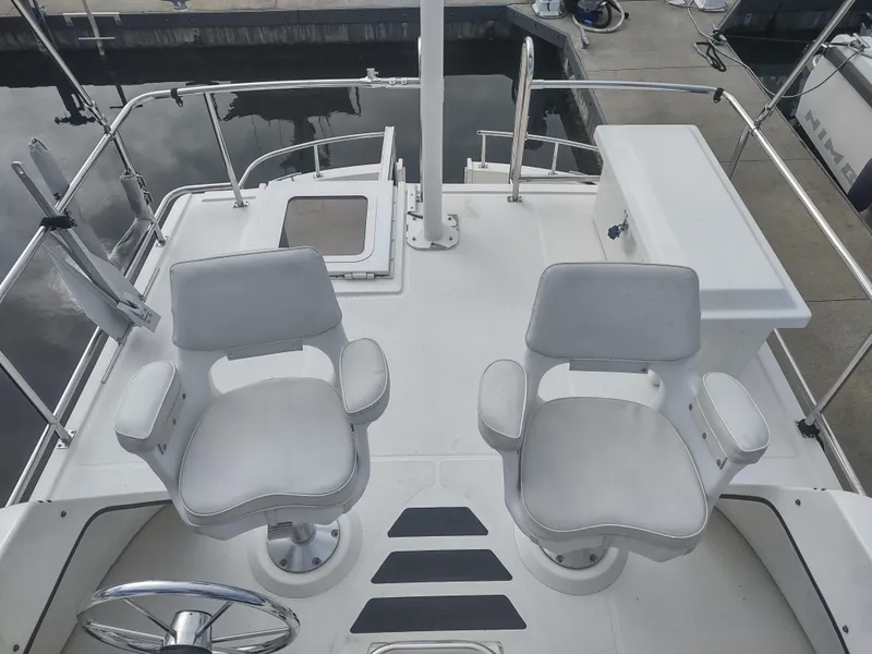 Slide: The Image of 2005 Nordic Tug 32 boat with two white seats on deck. - 12