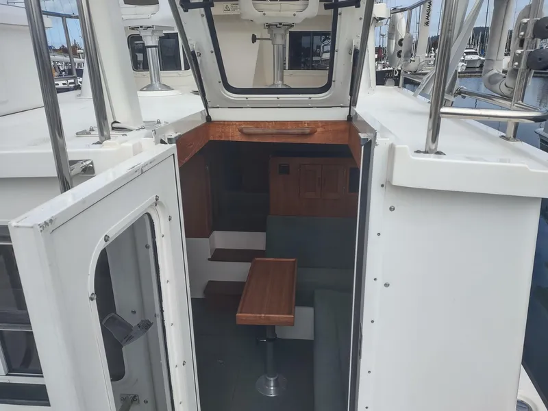 Slide: The Image of Interior of a 2005 Nordic Tug 32, featuring wooden table and seating area. - 26