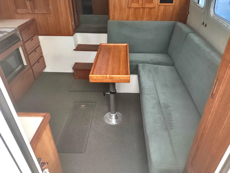 Slide: The Image of Interior of a 2005 Nordic Tug 32 with wooden table and gray sofa. - 27