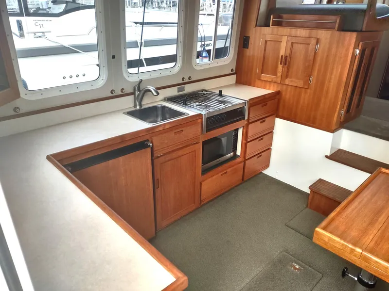 Slide: The Image of Interior of 2005 Nordic Tug 32 with kitchen and wooden cabinets. - 28