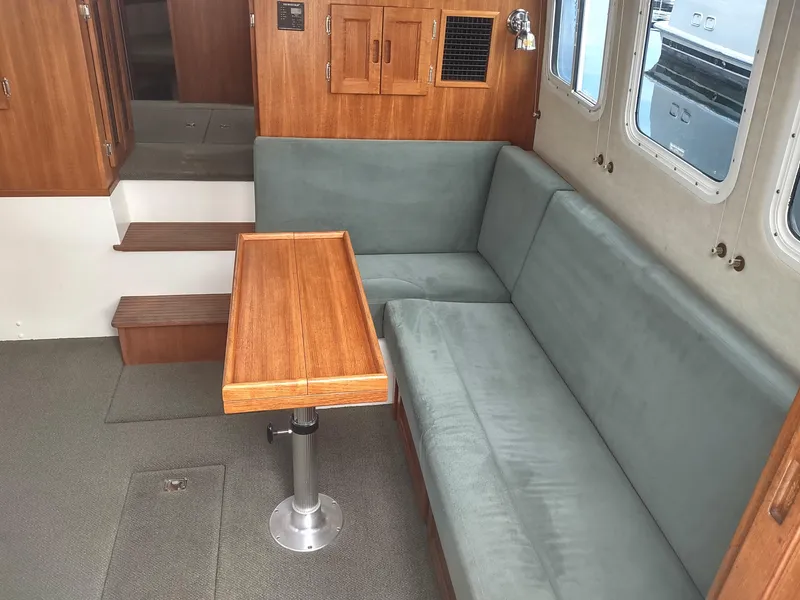 Slide: The Image of Interior of a 2005 Nordic Tug 32 with wooden table and green upholstery. - 29